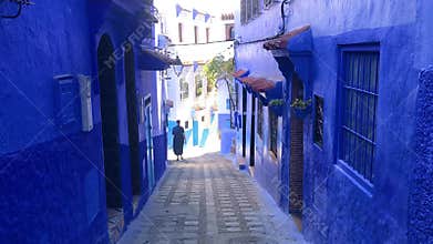 A men walking in street of the blue medina of town Chefchaouen in Morocco