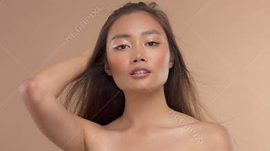 Thai asian model with natural makeup on beige background