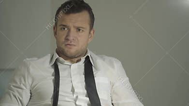 The guy detective in a white shirt listens to the interlocutor with a surprised face in his office