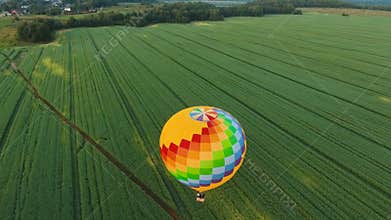 Hot air balloon in the sky over a field.