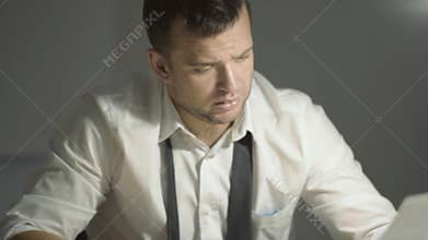 The guy detective in a white shirt listens to the interlocutor with a surprised face in his office