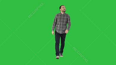 Young man walking looking up fascinated on a Green Screen, Chroma Key.