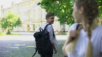 Two teens passing by each other and smiling, love at first sight, feelings