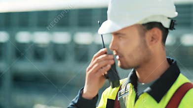 Metal worker in uniform and hard hat with walkie talkie medium close-up
