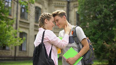 Couple of students in love hugging and nuzzling before classes, university life