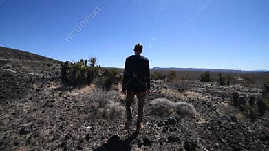 Lonely man walking on desert road