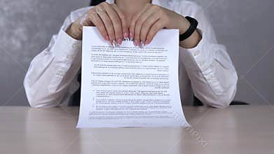 A serious business woman tearing a contract in pieces