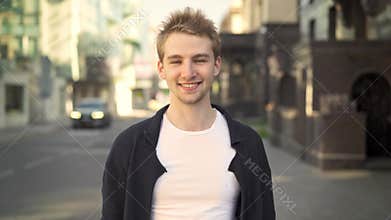 Blond man smiling and pointing at camera