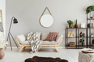 beige wall in stylish boho living room with elegant sofa and fury carpet