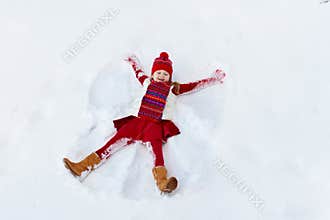 Child making snow angel on sunny winter morning. Kids winter outdoor fun. Family Christmas vacation. Little girl playing in snow