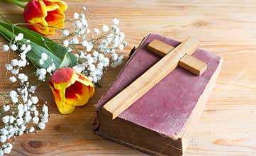 Spring easter flowers and cross on wooden background