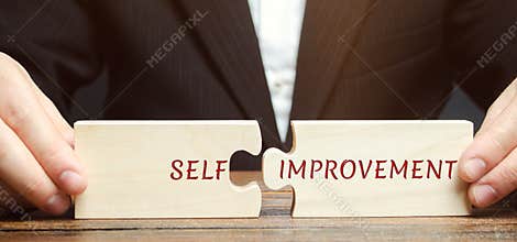 Businessman collects puzzles with the word Self-improvement. Concept of new business skills and motivation. Personal and career
