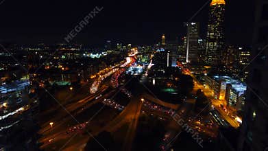 Flying between Atlanta commercial buildings. view of the lit-up city center and freeways with lots of cars in real time