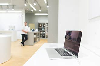 Laptop on the background of a bright modern electronics store