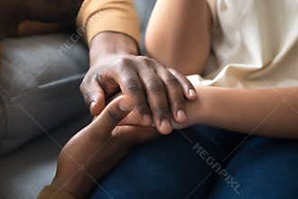 African father holding hands of child as charity support concept