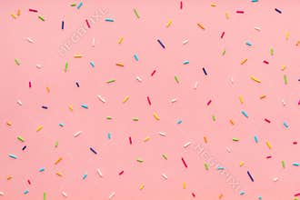 pattern of colorful sprinkles for background of design banner, poster, flyer, card, postcard, cover, brochure over pink