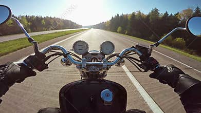 Fast motorcycle riding on highwa towards sun, wide point of view of rider. Classic cruiser/chopper forever!