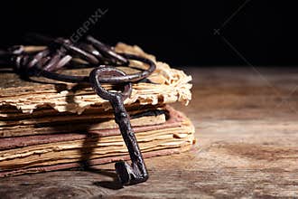Bunch of old vintage keys with books on wooden table