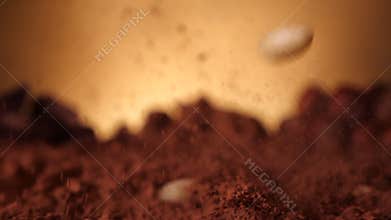 Peeled almonds splash into cocoa - slow motion