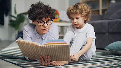 Adorable child boy is listening to fairy-tale while mom is reading story at home