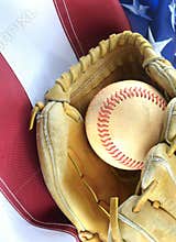 Closeup of worn baseball and mitt on a US flag background, great for America`s favorite pasttime. Vertical image.