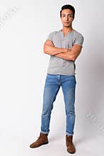 Full body shot of handsome Hispanic man with arms crossed