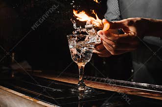 Glass of fiery cocktail on the bar counter