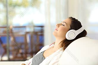 Woman relaxing listening to music on a couch