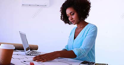 Female architect working on blueprint over drafting table 4k