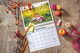 Fresh blank calendar open to September month, sticky note and pe
