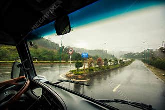 Highway along Tropical Plants under Heavy Rain out of Bus Window