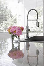 Vase of peonies on sink of modern kitchen