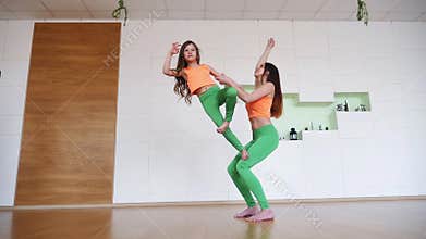Mother with her daughter practicing advanced yoga poses