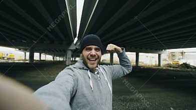 POV of Happy sportive man taking selfie portrait with smartphone after training in urban outdoors location in winter