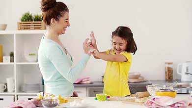 Happy mother and daughter making cookies at home