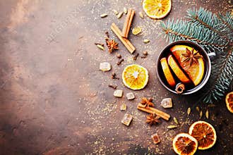 Christmas mulled wine or gluhwein with spices and orange slices on rustic table top view. Traditional drink on winter holiday.