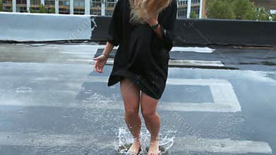 Girl enjoys rain on the rooftop of her house