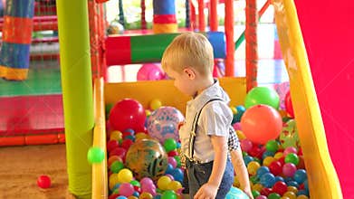 Two little boy playing in the dry pool with balls.