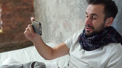 Positive minded sick man coughing while having video call