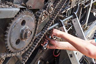 Combine machine service, mechanic repairing motor outdoors