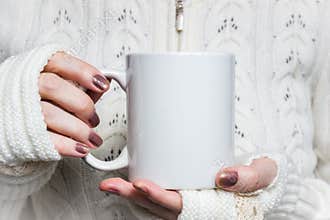 Woman holds white mug in hands. Design Mockup for winter holidays
