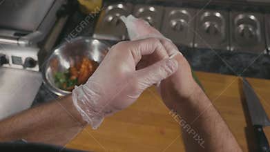 Chef preparing for cook food in restaurant, he putting the latex gloves