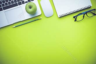 Office desk table with laptop and supplies.