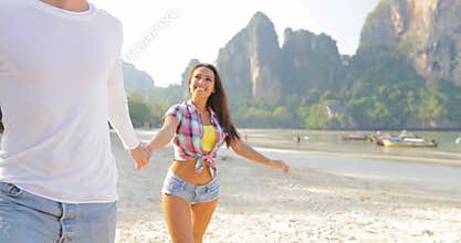 Man Leading Woman Couple Walking On Beach Holding Hands Talking Young Tourists On Vacation