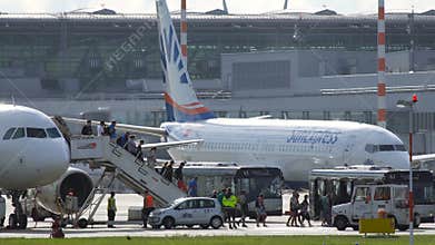 Passengers walk on gangway after approaching at Dusseldorf International Airport.