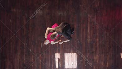 Professional couple dancing tango on the wooden floor in the studio.