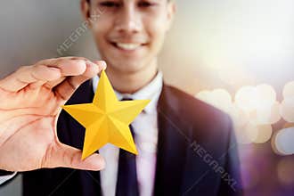 Success in Business or Personal Talent Concept. Happy Businessman in black suit Smiling and Showing a Golden Star in Hand