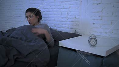 Lateral panning shot of young attractive hispanic woman upset in stress and insomnia lying anxious on bed trying to sleep