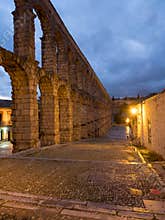 Segovia, Spain at the ancient Roman aqueduct. The Aqueduct of Segovia, located in Plaza del Azoguejo, is the defining historical f