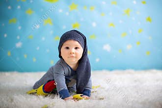 Little baby boy with cute teddy bear and moon on a blue star and